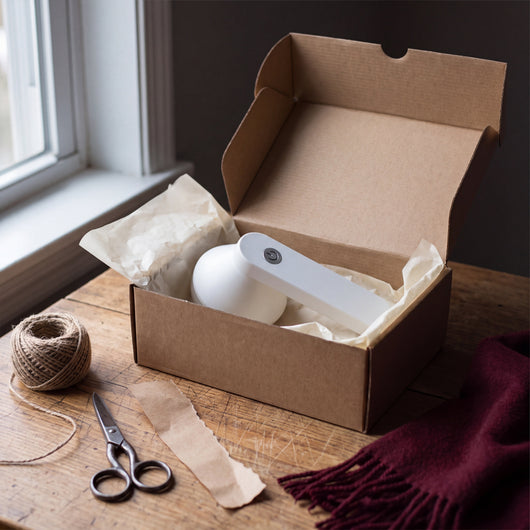 White Novum Electric Lint Remover in a plain gift box