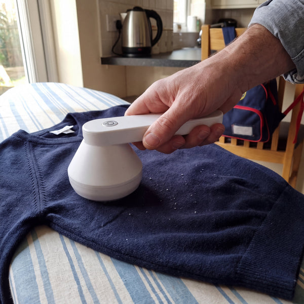 White electric lint remover used on a navy school jumper