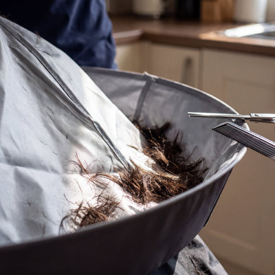 Cut hair collected in the deep groove of the cutting cape brim