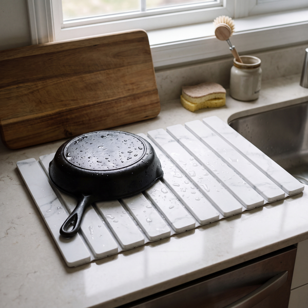 Stone drying mat by the sink with a wet cast-iron pan on it