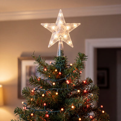 Lit star topper on the tip of a tree