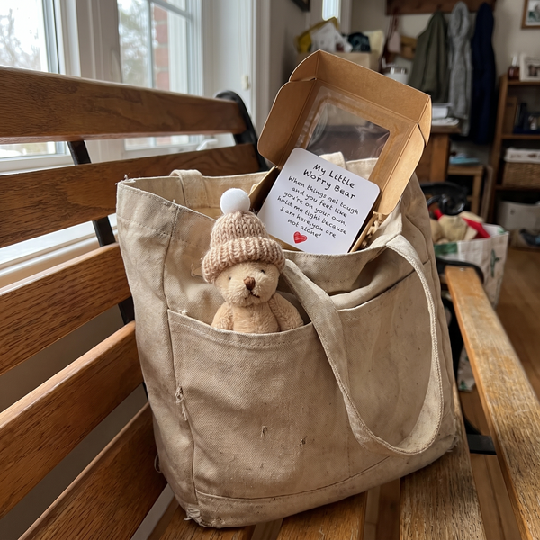 Novum Worry Bear peeking out of a tote bag pocket