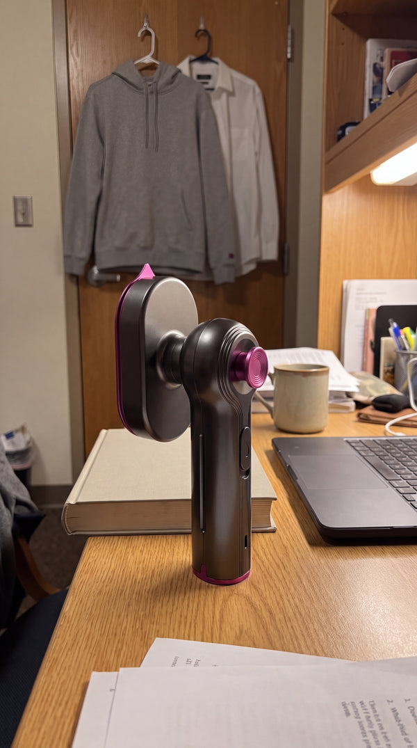 The Novum Mini Steam Iron on a dorm desk with pressed clothes on the door
