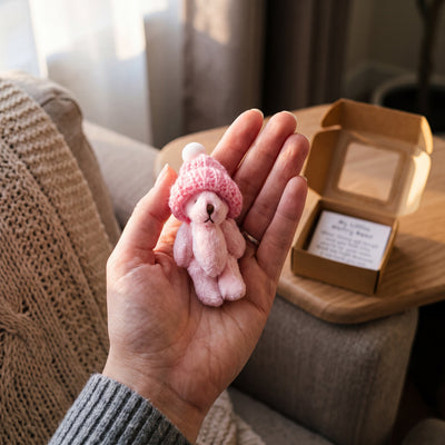 Novum Worry Bear in Pink held in an open palm to show its size